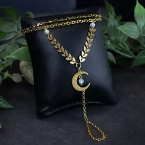 Whimsical lunar slave bracelet styled in a dark romantic setting with dried leaves and soft, moody lighting.