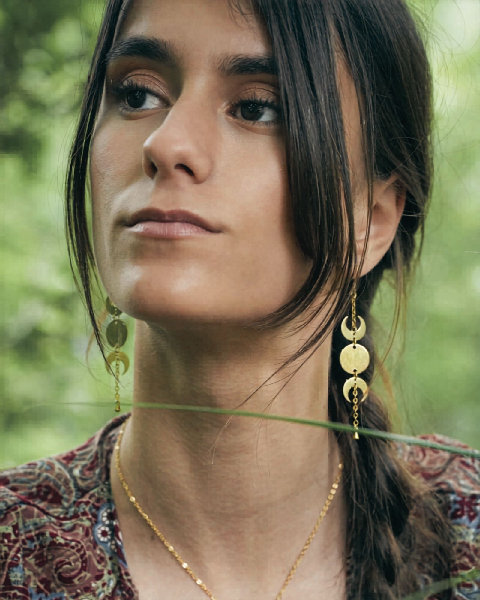 Girl wearing golden moonphase earrings.